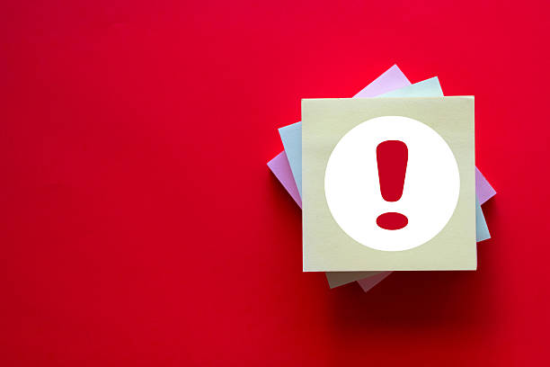 A red exclamation mark icon on a sticky note. A concept for warnings, danger, alerts, errors, and risk. A symbol for important safety notices, problems, or hazards. Red background with copyspace.
