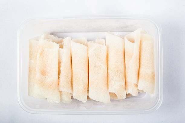 Frozen sliced lamb rolls isolated on white background, showcasing fresh meat texture and marbled fat layers, representing frozen food, hotpot ingredients, and quality meat industry concept.