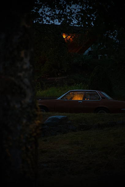 istock Retro car lit up on a rainy night 2242155888