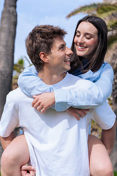 istock Young couple outdoors in vertical format smiling together in romantic moment 2242158990