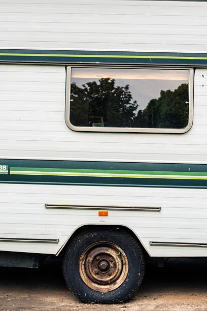 istock Flat tire on old camper with green stripe exterior 2242159245