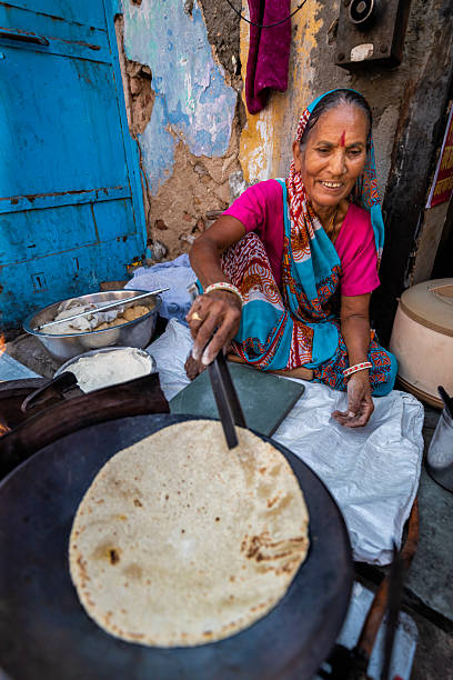 Indian street vendor preparing food - chapatti, flat bread, in The Pink City of Jaipur, Rajasthan, India.  Jaipur is known as the Pink City, because of the color of the stone exclusively used for the construction of all the structures.