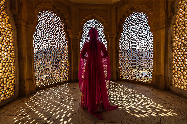 istock Young Indian woman looking through the window 2242160343