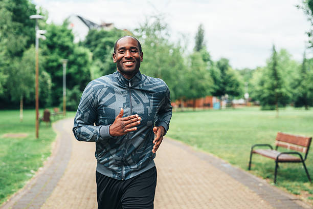 istock Smiling man jogging outdoors in the park. 2242160839