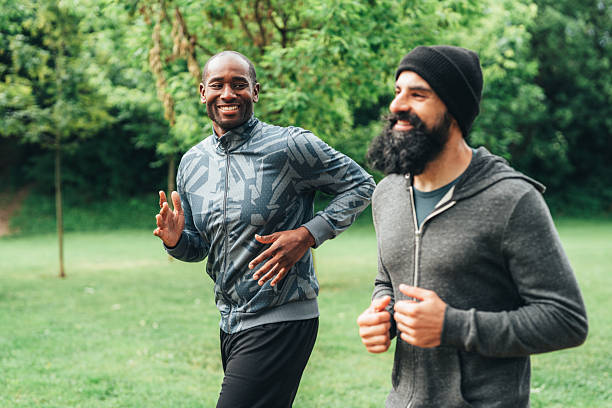 istock Cardio training outdoors. Happy athletes having fun while running together in nature. 2242160855