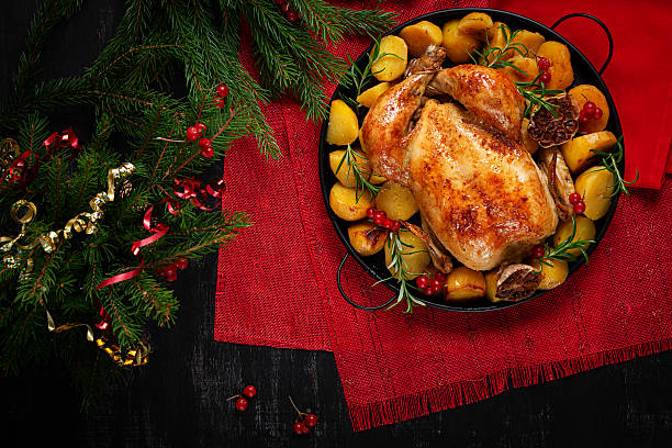 istock Roasted chicken with potatoes and Christmas decoration. Baked chicken or turkey. Table setting. Top view, flat lay 2242163761