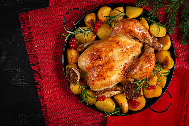istock Roasted chicken with potatoes and Christmas decoration. Baked chicken or turkey. Table setting. Top view, flat lay 2242163764
