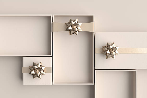 Minimal composition of open empty gift boxes with golden bows and ribbons waiting to be filled on pastel beige background