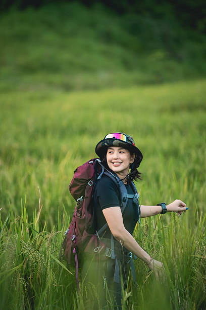 istock Young woman exploring vibrant green rice fields with a backpack on a sunny day, enjoying the beauty of nature and adventurous spirit of hiking outdoors 2242167639