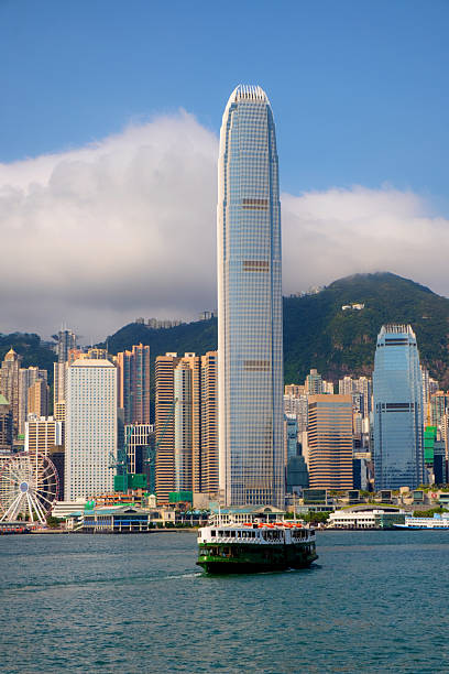 One of Hong Kong's iconic Star Ferries approaches the ferry terminal at Tsim Sha Tsui. The modern skyscrapers of Hong Kong Island can be seen in the background.