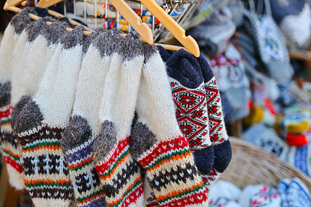 istock Colorful knitted socks and sweaters displayed at market stall 2242171876