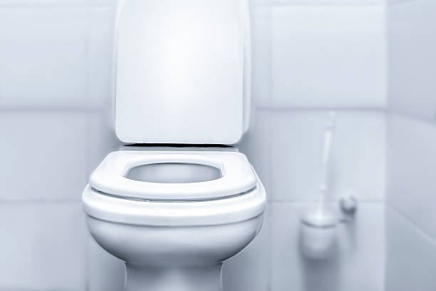 istock This minimalist toilet features a sleek, white design set against a light-colored wall. The room emphasizes a clean and simple aesthetic, perfect for a modern bathroom. 2242174120