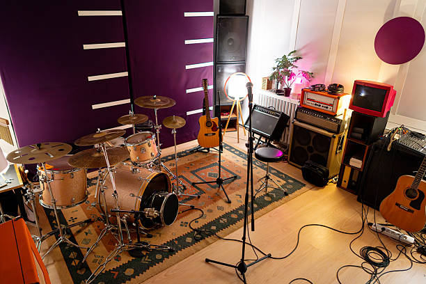istock Full music studio with drum set, guitars, amplifiers, and a microphone on a stand against a purple wall 2242174590