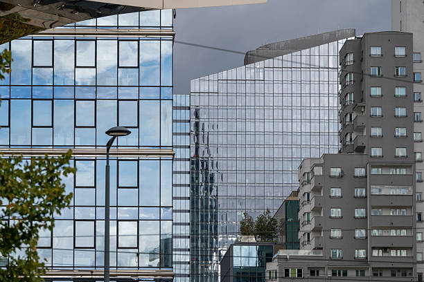 A mix of contemporary glass buildings and residential architecture under cloudy skies, showcasing Warsaw, Poland’s evolving urban skyline and modern city design.