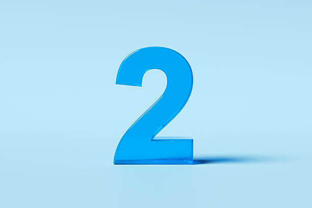 istock Large, blue, translucent number two standing on a light blue background 2242178101