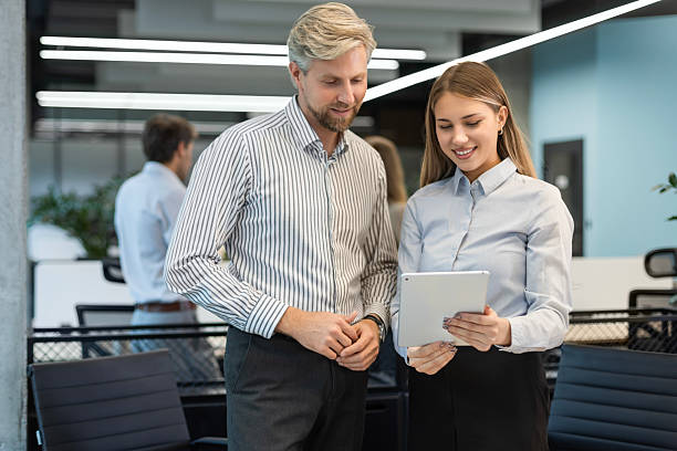 istock Two diverse business partners standing and discussing project working together in digital tablet 2242179885