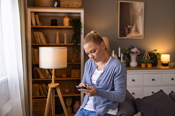 istock Beautiful woman scrolling the net and resting while sitting on the sofa near the window. 2242183470