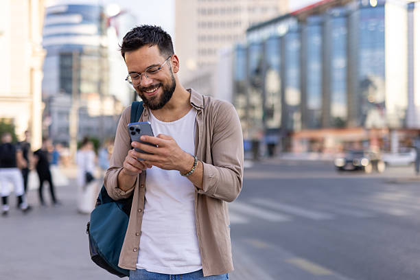 istock Man sending text on phone joyfully in bustling urban scene 2242184761