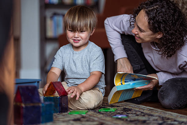 istock Smiling little boy playing at home with his mom 2242185878