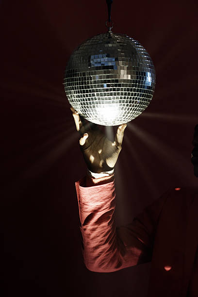 istock Hand of Man Holding Disco Ball in Dark Studio 2242186422