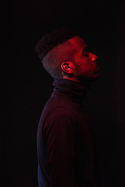 istock Side Portrait of Young Black Man in Darkness 2242186543