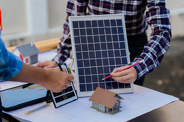 istock Two young engineers, experts in solar cell installation, meeting and discussing at the factory building, planning the installation of solar panels on the roof. 2242186561