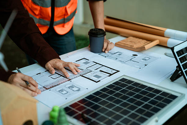 istock Two young engineers, experts in solar cell installation, meeting and discussing at the factory building, planning the installation of solar panels on the roof. 2242186578