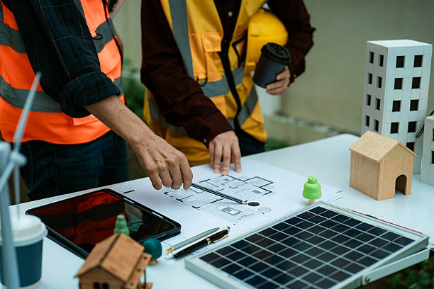 istock Two young engineers, experts in solar cell installation, meeting and discussing at the factory building, planning the installation of solar panels on the roof. 2242186594