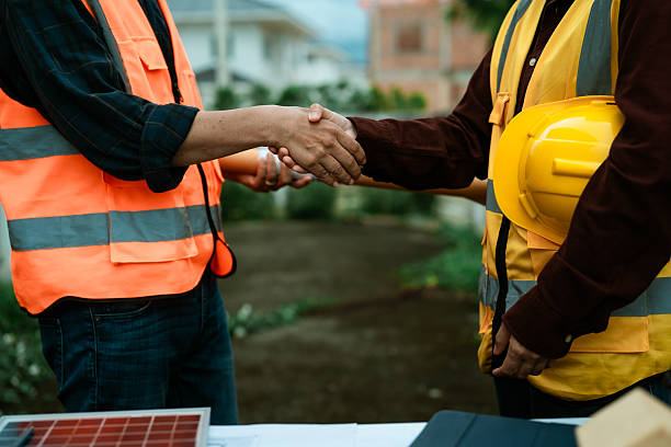 istock Two young engineers, experts in solar cell installation, meeting and discussing at the factory building, planning the installation of solar panels on the roof. 2242186598