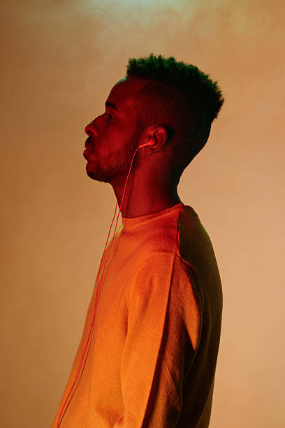 istock Young Black Man with Earphones on Yellow Background 2242188159
