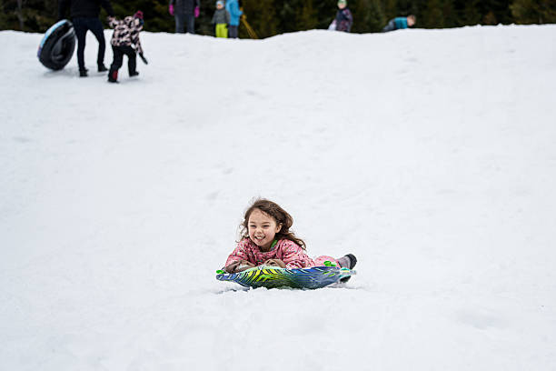 istock Young girl having fun snow sledding 2242188591