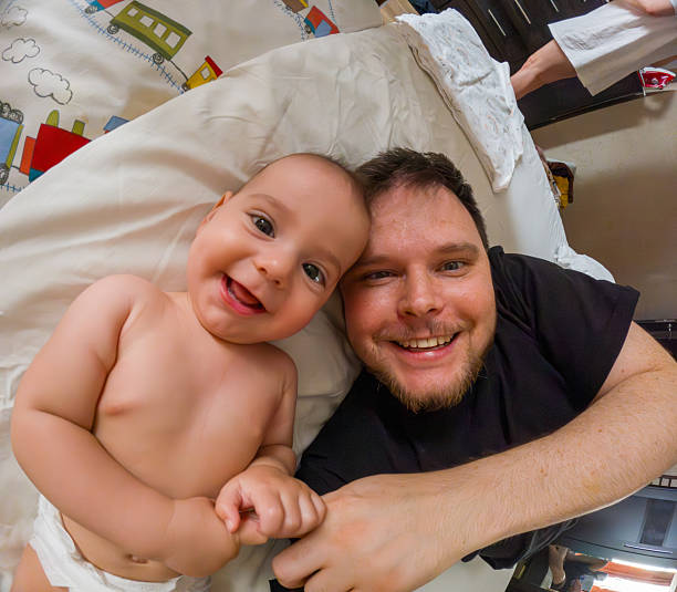 istock Father and Baby Smiling on Bed 2242189384