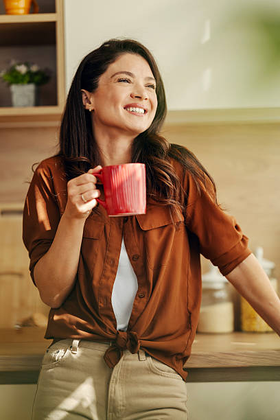 istock Woman enjoying morning coffee in kitchen, smiling 2242192634