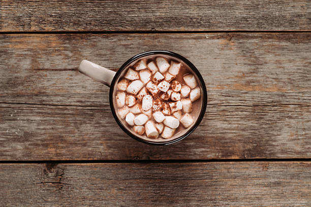 istock Overhead view of hot chocolate with marshmallows and cocoa powder on rustic background 2242193198