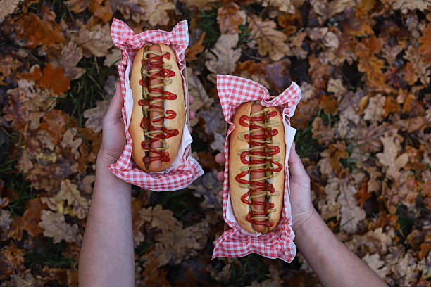 A hot dog in the hands of a man