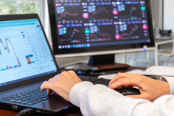 istock Hands typing on laptop while checking stock market trends on multiple screens in a modern office setup 2242194972