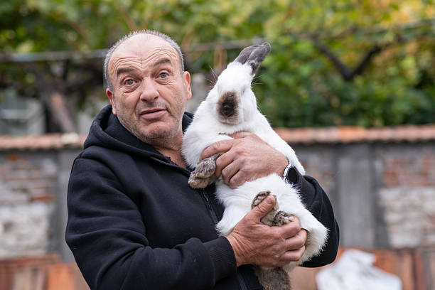 istock Man Holding Rabbit with Surprised Expression Outdoor 2242195490