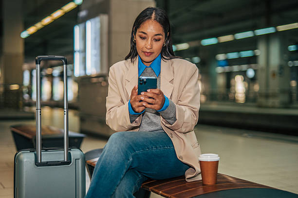 istock Woman checking phone while waiting at train station 2242195608