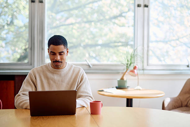 Young man remote working on laptop from home office