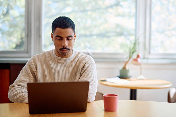 istock Man working remotely on laptop from home office desk 2242196981