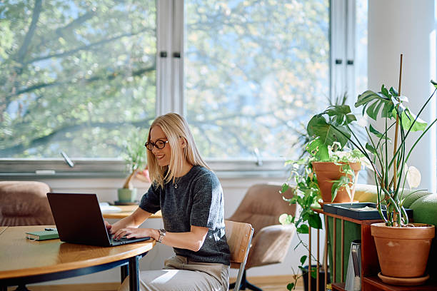 istock Woman working on laptop while smiling at home 2242197912