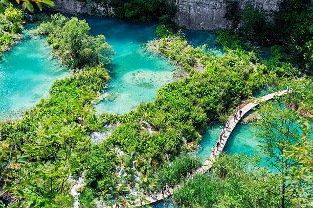 istock Scenic view Plitvice lakes turquoise waters surrounded by lush greenery rocky cliffs Croatia National Park with wooden pathways for visitors tourists to explore. Stunning nature greenery landscape 2242198071