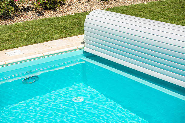 istock Relaxing Poolside View Showing Clear Water and Pool Cover During Sunny Day 2242200263