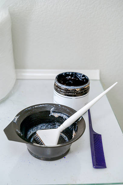 istock A plastic brush for applying hair mask in a black plastic container next to a container 2242201255