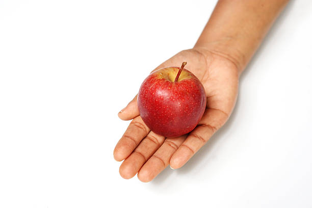 Hand Holding Ripe Red Apple Isolated on White.