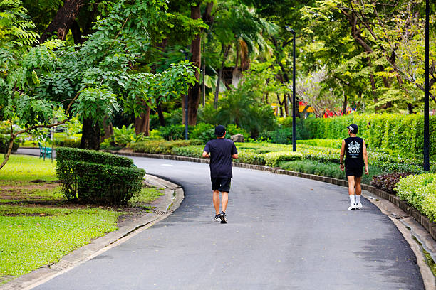 Young woman is jogging on pedestrian walkway at sunset.