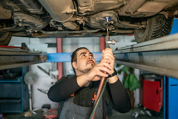 istock Mechanic Under Car On Lift Using Wrench To Perform Auto Repair In Workshop 2242210650