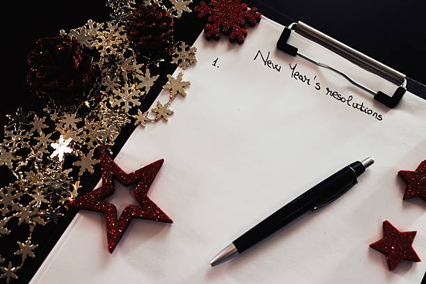 istock Writing New Year`s Resolutions for Christmas. Christmas Resolutions. Text New Year`s Resolutions on paper. 2242212274