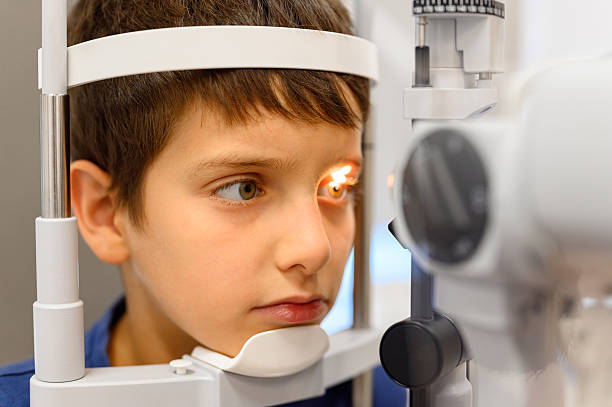 istock Close-up of boy undergoing eye examination with slit lamp for clear vision checkup at ophthalmology clinic 2242212502