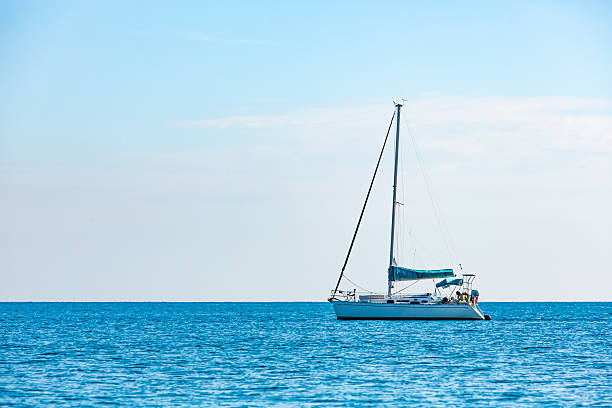 istock Sailing Boat on Calm Sea Under Clear Sky 2242212741